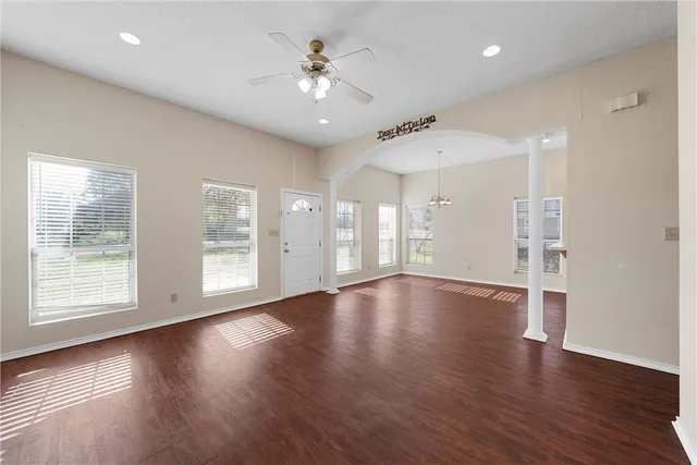 an empty room with wooden floor and window