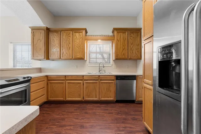 a kitchen with stainless steel appliances granite countertop a stove a sink and a refrigerator