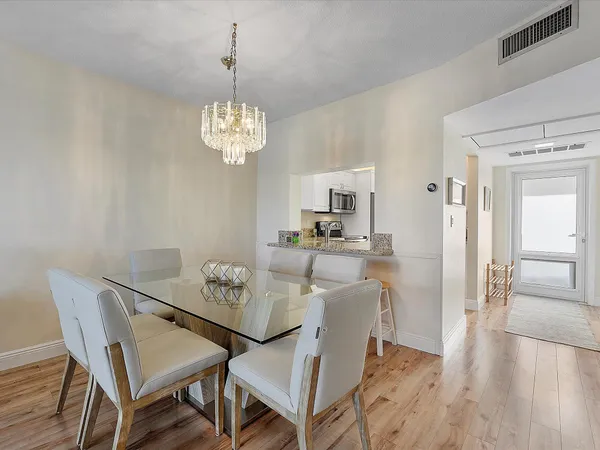 a view of a dining room with furniture wooden floor and a chandelier