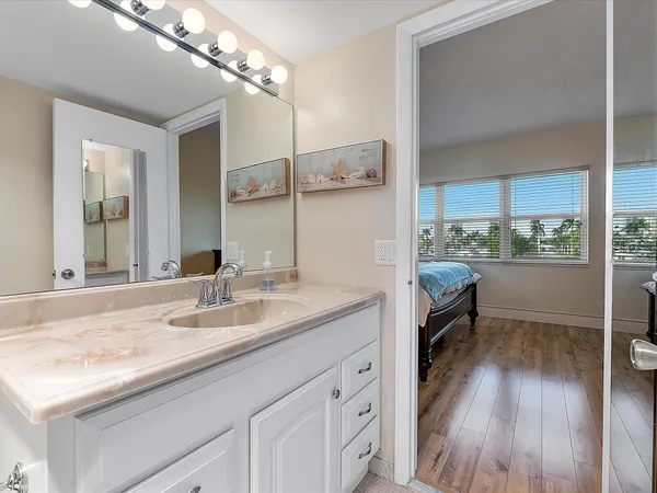 a en suite bathroom with a granite countertop sink toilet and a mirror