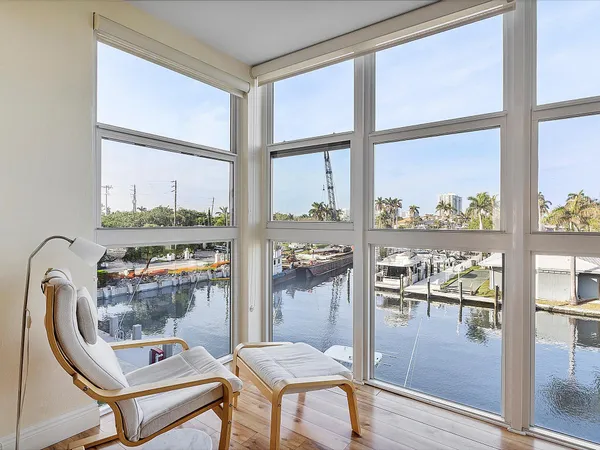 a dining room with furniture and a floor to ceiling window