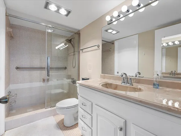 a bathroom with a sink a toilet and shower