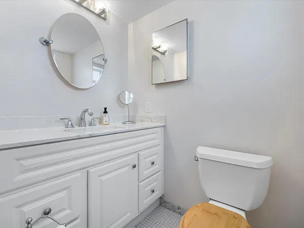 a bathroom with a toilet a sink and mirror