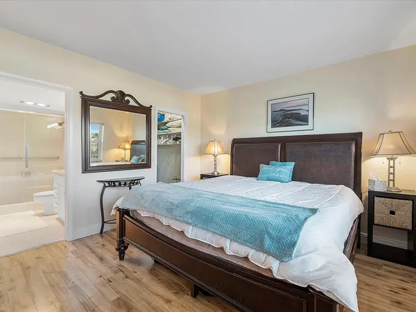 a bedroom with a bed and a dresser with mirror