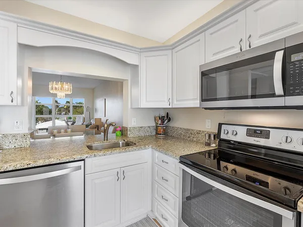 a kitchen with sink stove and cabinets