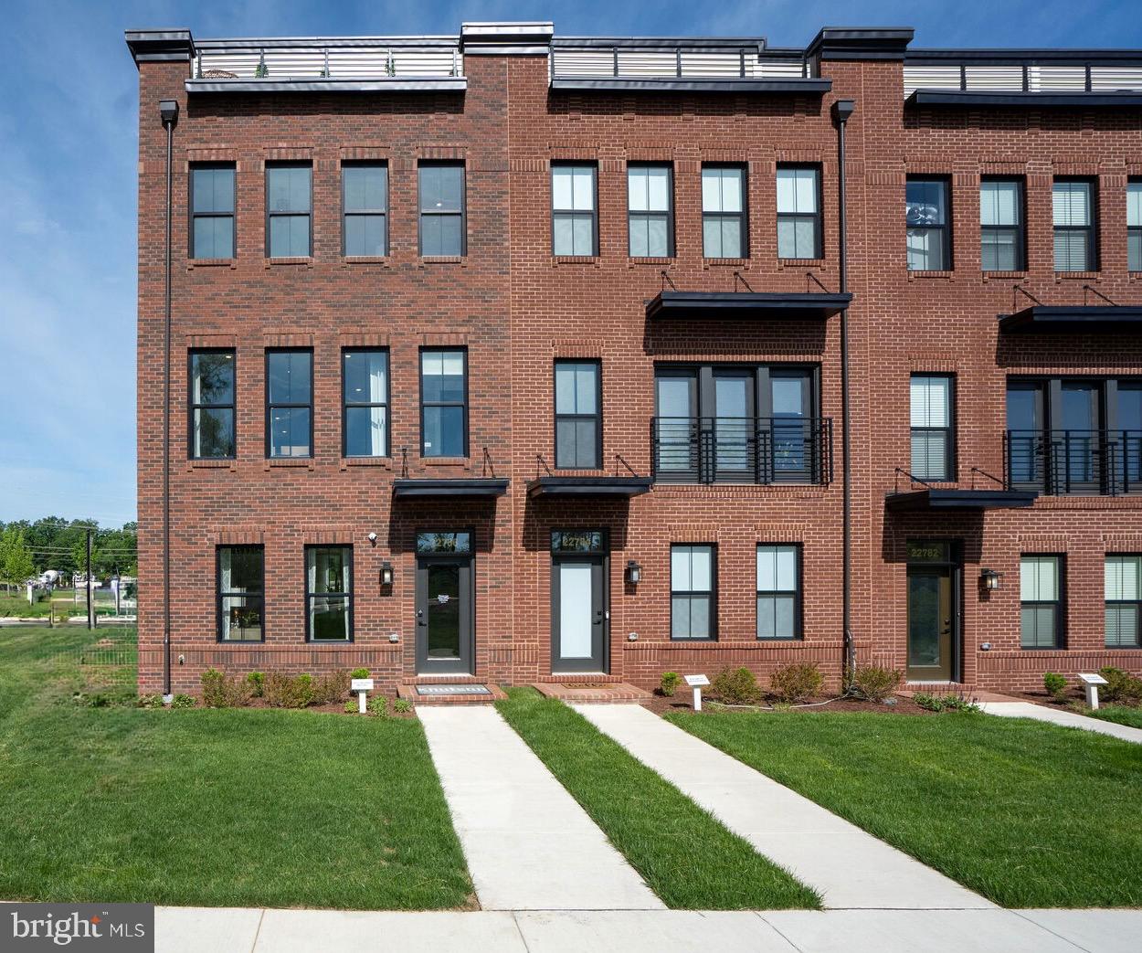 22786 Hanson Overlook Terrace Ashburn, VA 20148 - Photo 1 of 21 a front view of a residential apartment building with a yard