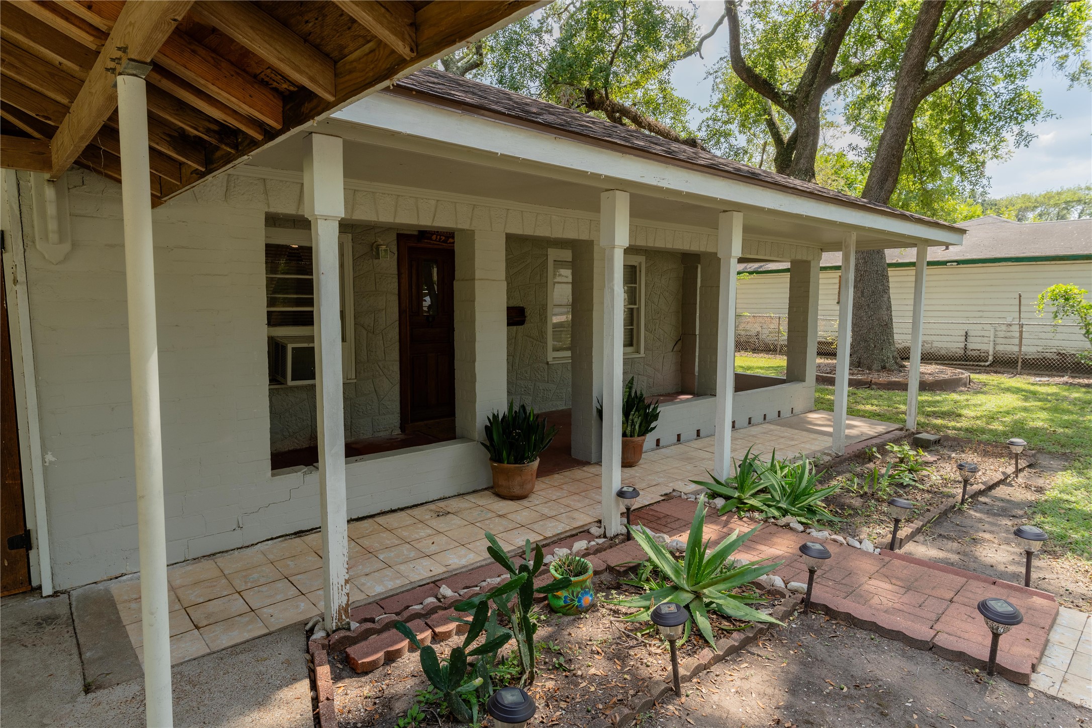 417 Hardy Street Clute, TX 77531 - Photo 26 of 28 a backyard of a house with potted plants and large tree