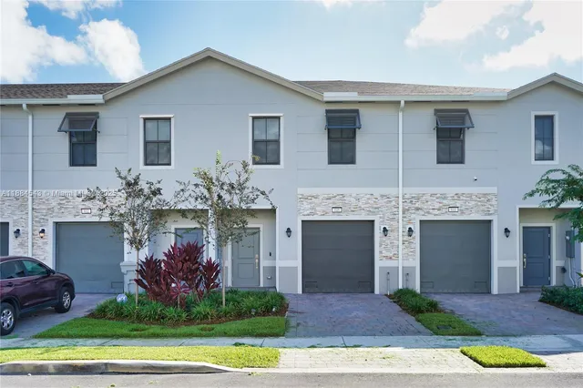 a front view of a house with a yard and garage