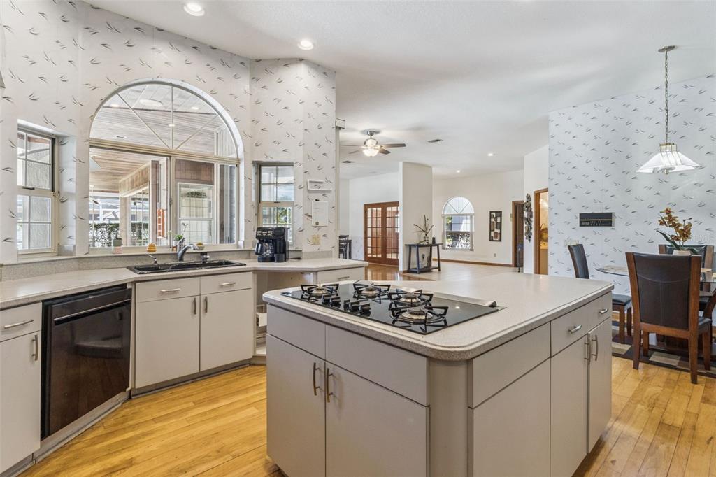 2964 Plantation Road Winter Haven, FL 33884 - Photo 12 of 42 a kitchen with a stove a sink dishwasher and white cabinets with wooden floor