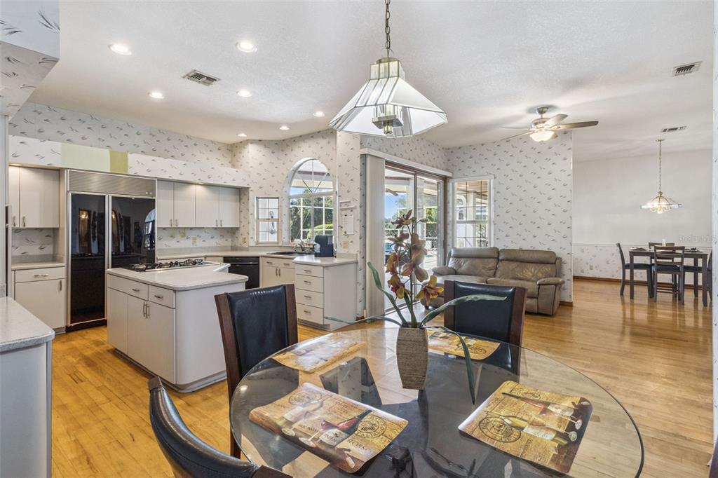 2964 Plantation Road Winter Haven, FL 33884 - Photo 14 of 42 a kitchen with stainless steel appliances granite countertop a stove a refrigerator a kitchen island a dining table and chairs