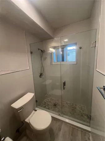 a bathroom with a toilet and a shower
