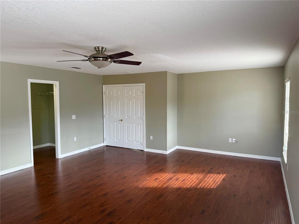 1037 Berkeley Drive Kissimmee, FL 34744 - Photo 13 of 38 a view of an empty room with wooden floor