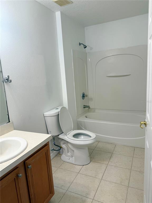 1037 Berkeley Drive Kissimmee, FL 34744 - Photo 20 of 38 a white toilet sitting next to a bath tub and a shower