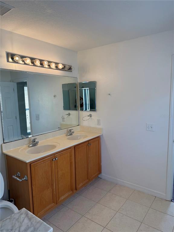 1037 Berkeley Drive Kissimmee, FL 34744 - Photo 24 of 38 a bathroom with a sink and a mirror