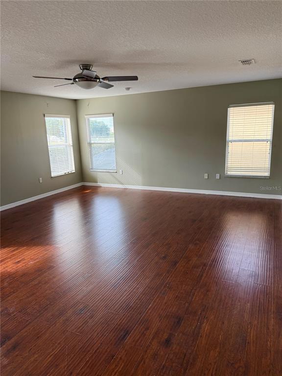 1037 Berkeley Drive Kissimmee, FL 34744 - Photo 27 of 38 an empty room with wooden floor and windows
