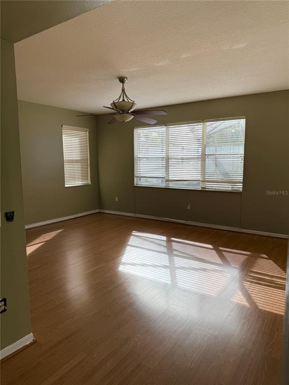 1037 Berkeley Drive Kissimmee, FL 34744 - Photo 30 of 38 a view of an empty room with wooden floor and a window