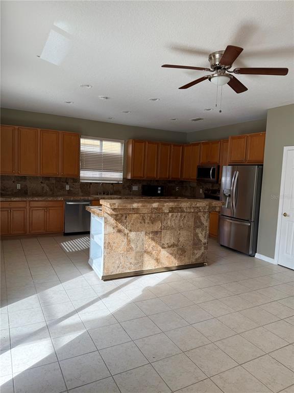 1037 Berkeley Drive Kissimmee, FL 34744 - Photo 6 of 38 a kitchen with stainless steel appliances granite countertop a stove a sink and a refrigerator