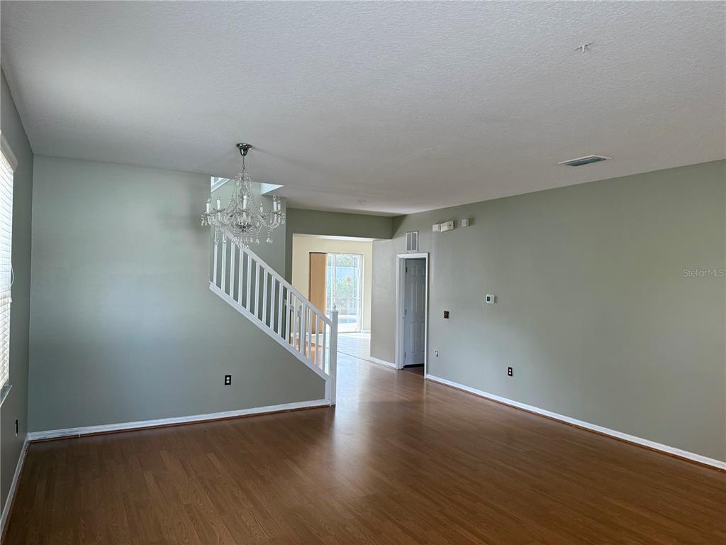 1037 Berkeley Drive Kissimmee, FL 34744 - Photo 10 of 38 an empty room with wooden floor and windows