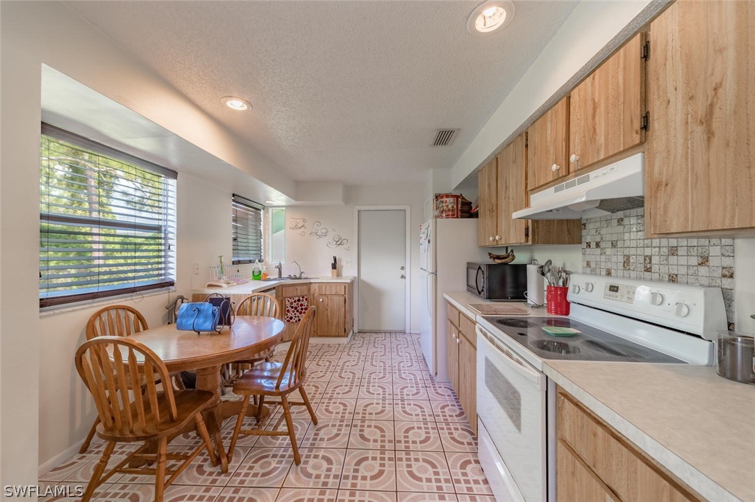 18558 Sunflower Road Fort Myers, FL 33967 - Photo 6 of 18 a kitchen with a dining table chairs and a sink