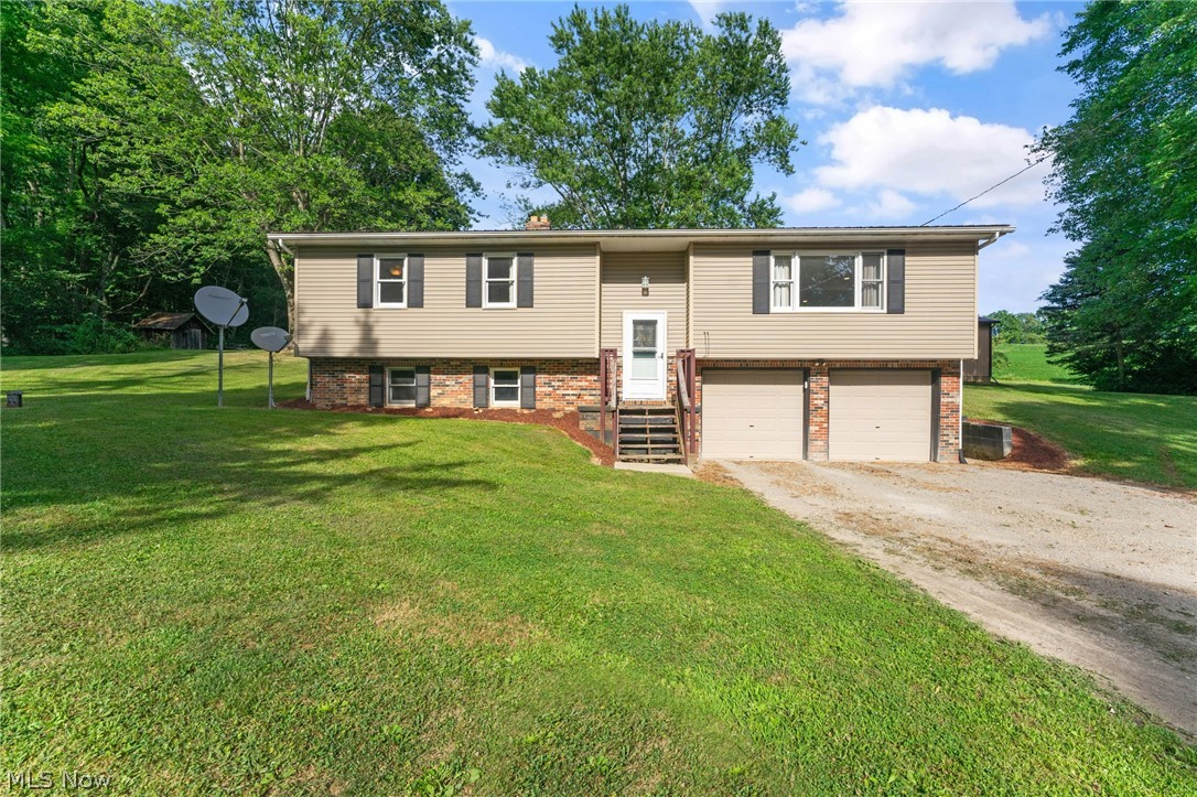8184 Rochester Road East Rochester, OH 44625 - Photo 2 of 28 Raised ranch featuring a garage and a front yard