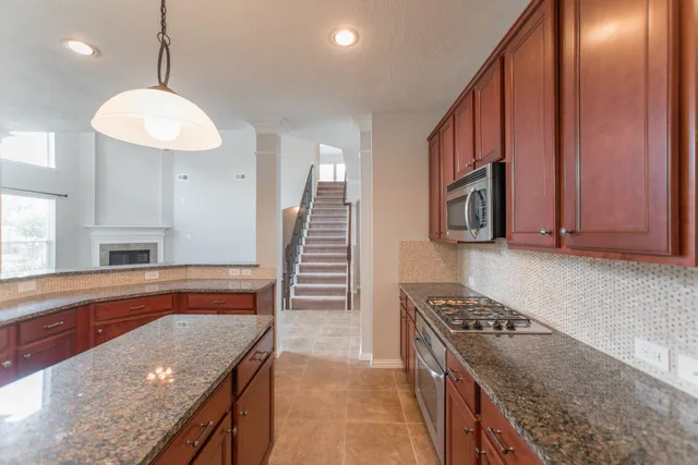a kitchen with stainless steel appliances granite countertop a stove a sink and a refrigerator