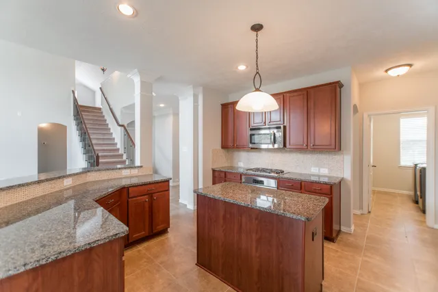 a kitchen with a sink a counter space appliances and cabinets