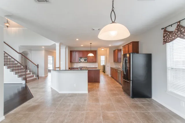 a view of a kitchen with refrigerator and a wooden floor