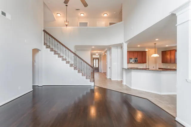 a view of a room with wooden floor and a kitchen view