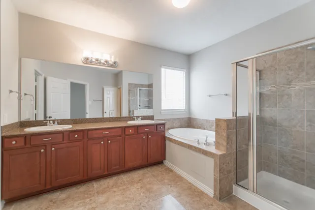 a spacious bathroom with a granite countertop tub sink and mirror