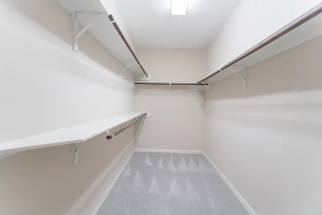 a view of walk in closet with empty racks