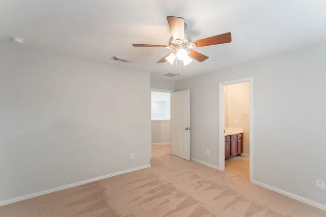 an empty room with closet and a chandelier fan