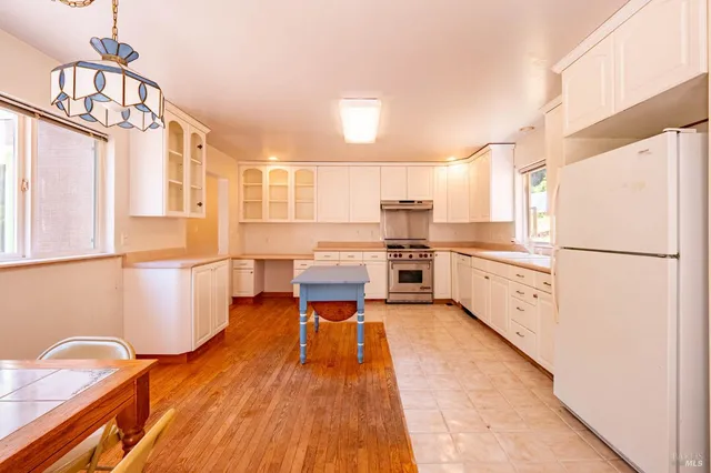 a kitchen with stainless steel appliances a refrigerator sink and cabinets