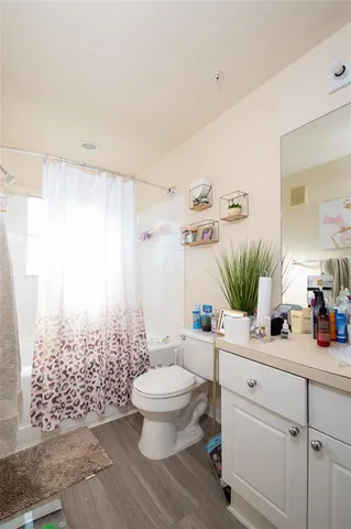 a bathroom with a toilet a sink and a large mirror