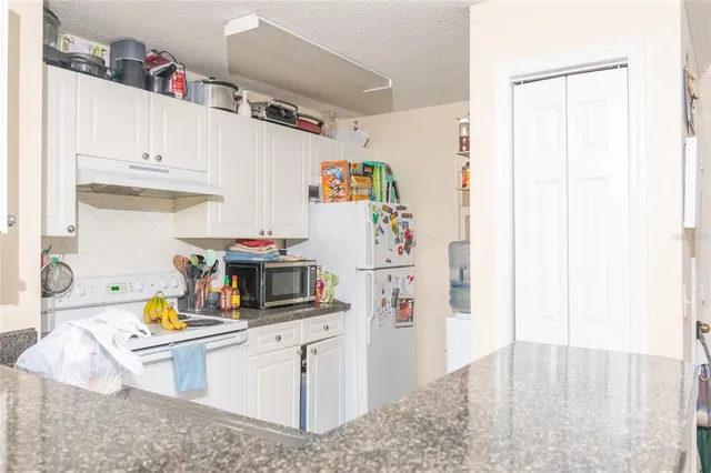 a kitchen with refrigerator and cabinets