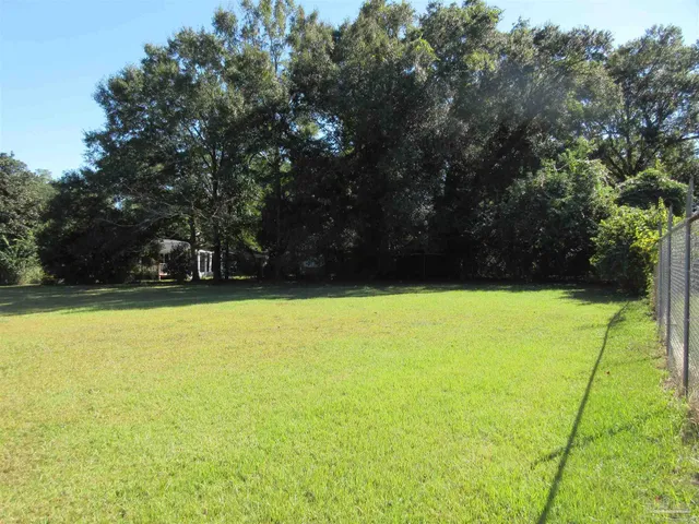 a view of outdoor space with green field and trees all around