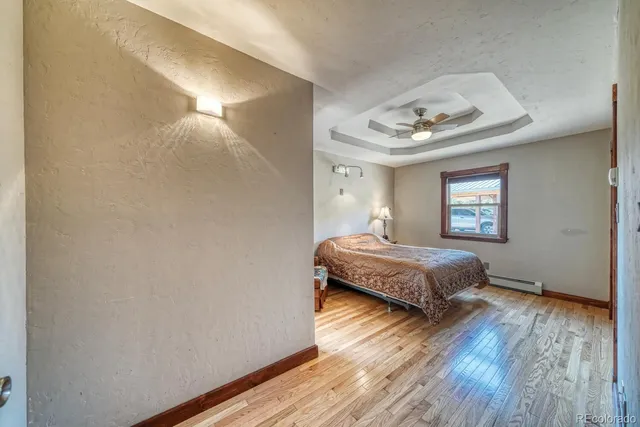 a bedroom with a bed and wooden floor