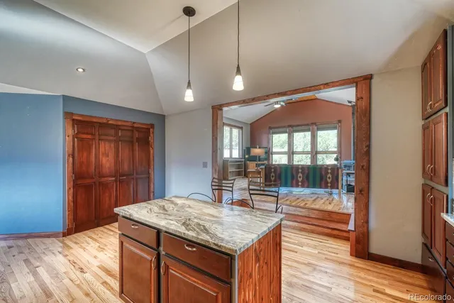 a kitchen with kitchen island a counter top space a sink stainless steel appliances and cabinets