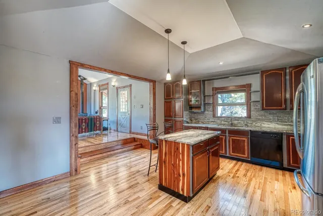 a kitchen with stainless steel appliances granite countertop wooden cabinets and sink