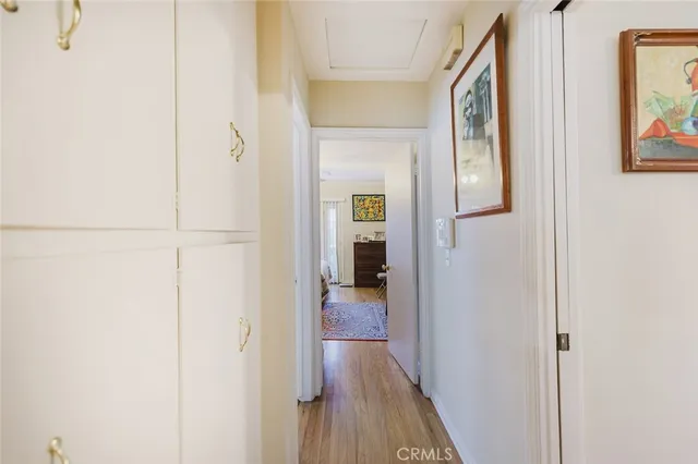 a view of a hallway with wooden floor and closet