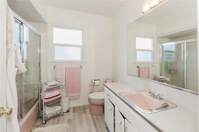 a bathroom with a granite countertop sink a toilet and shower curtain