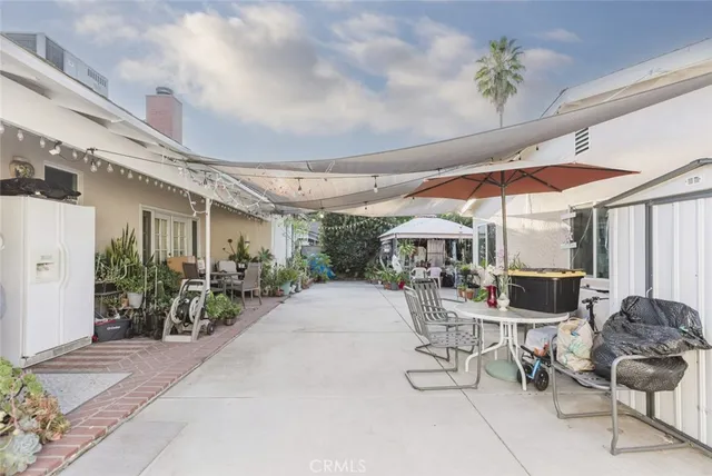 a view of a patio with table and chairs under an umbrella