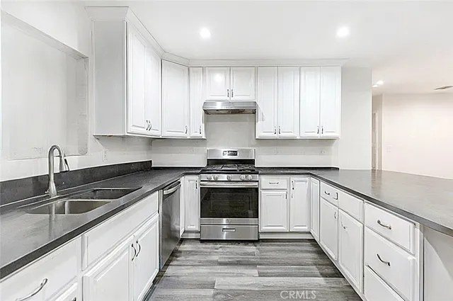 a kitchen with cabinets stainless steel appliances and a sink