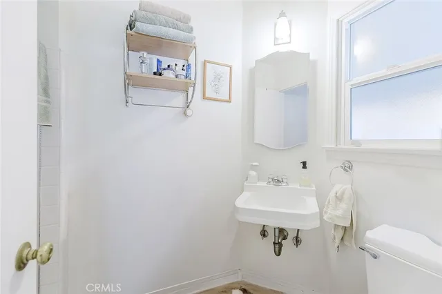 a bathroom with a sink mirror and toilet