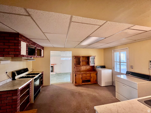 479 East 100 N Road Meadow, UT 84644 - Photo 12 of 59 Kitchen featuring range with gas stovetop, light colored carpet, a paneled ceiling, washer and dryer, and light countertops