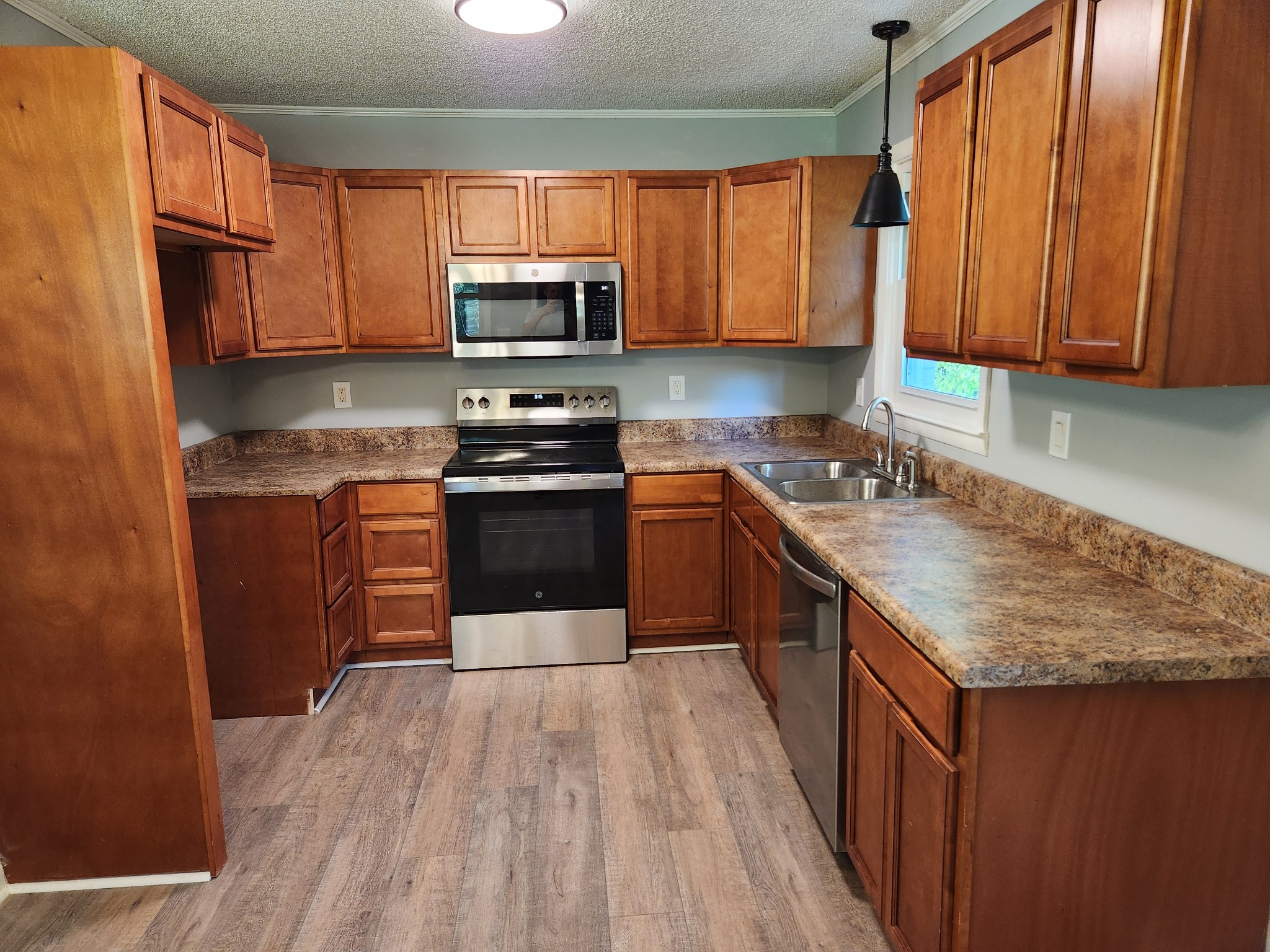 3262 Prospect Road Pulaski, TN 38478 - Photo 6 of 23 a kitchen with stainless steel appliances granite countertop wooden cabinets a stove top oven a sink and dishwasher with wooden floor