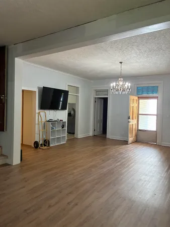 a view of a livingroom with a flat screen tv wooden floor and a fireplace