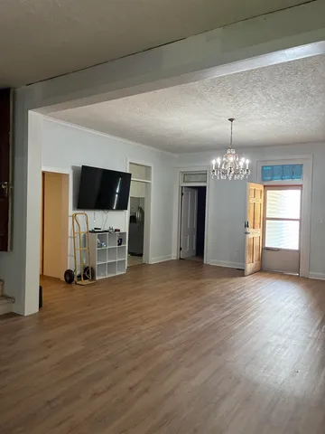a view of a livingroom with a flat screen tv wooden floor and a fireplace