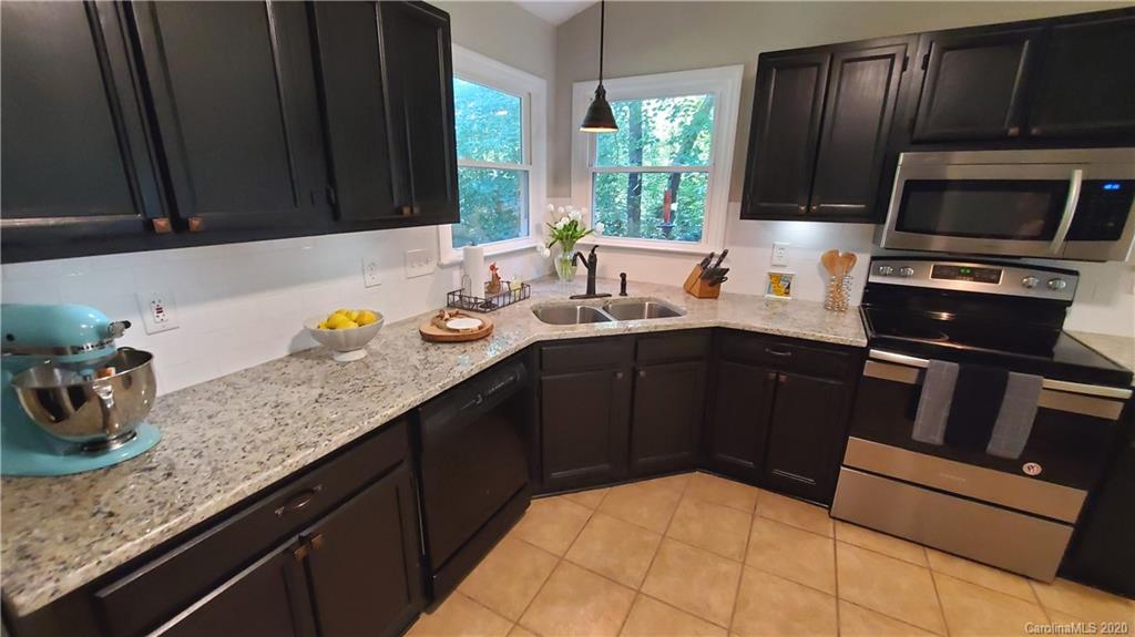 20700 Willow Pond Road Cornelius, NC 28031 - Photo 12 of 47 a kitchen with granite countertop a sink dishwasher stove and cabinets