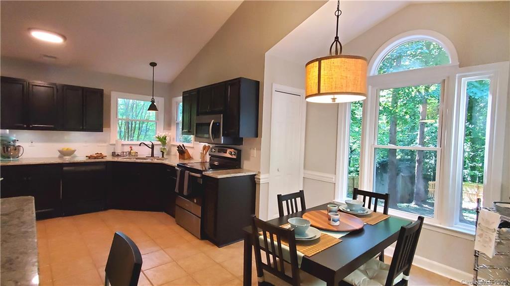 20700 Willow Pond Road Cornelius, NC 28031 - Photo 14 of 47 a kitchen with a table chairs refrigerator and microwave