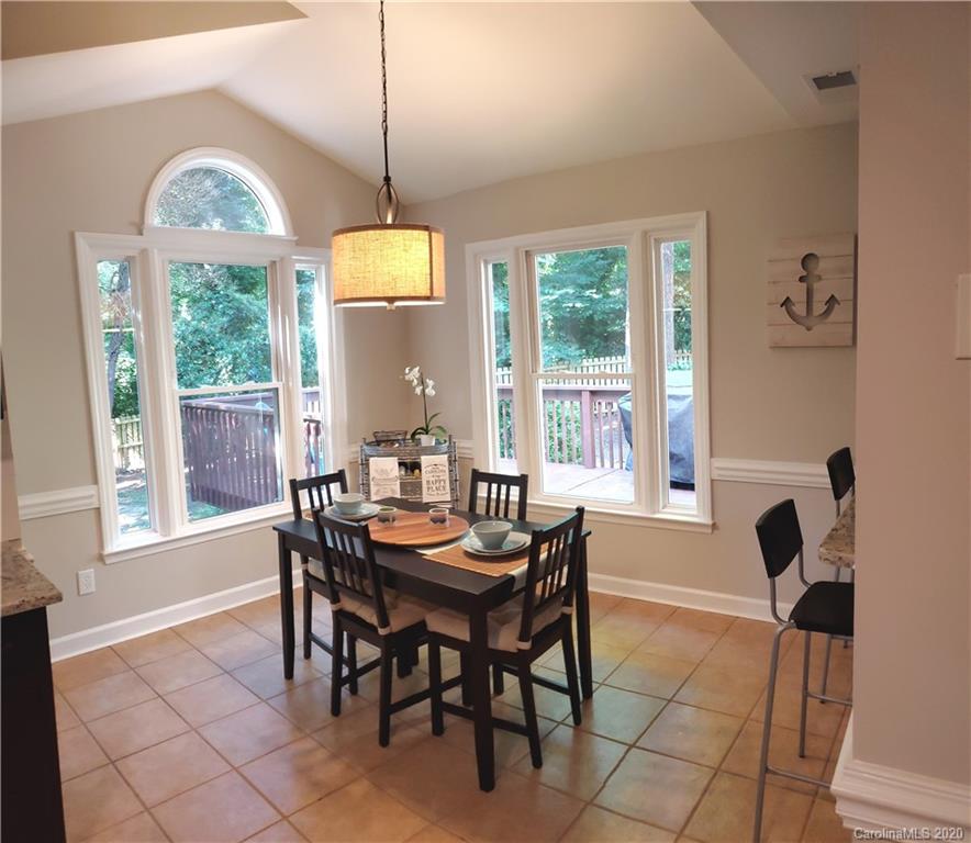 20700 Willow Pond Road Cornelius, NC 28031 - Photo 17 of 47 a dining room with furniture a chandelier and wooden floor